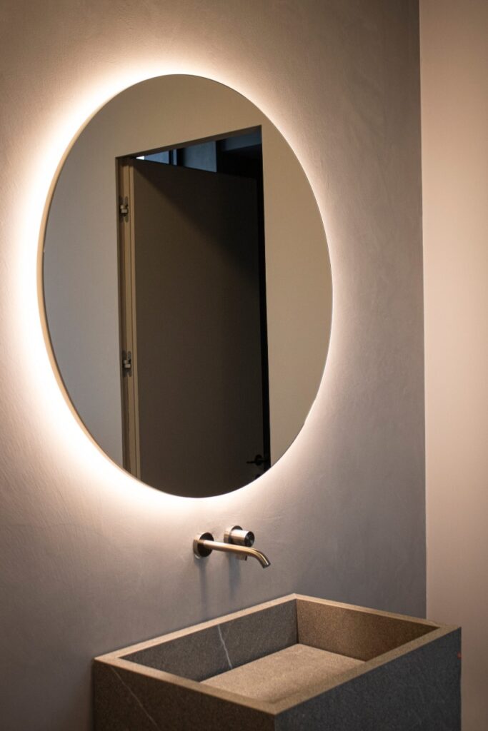 Specchio rotondo retroilluminato a LED in un bagno