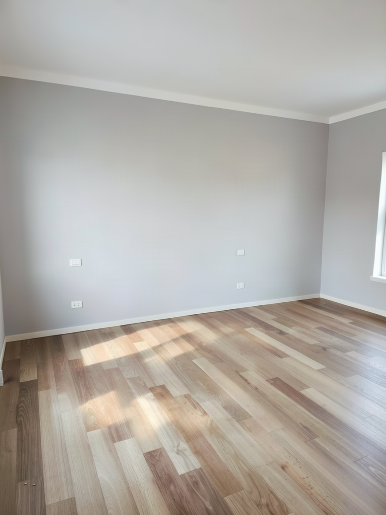 Camera da letto con parete grigia e pavimento in legno chiaro