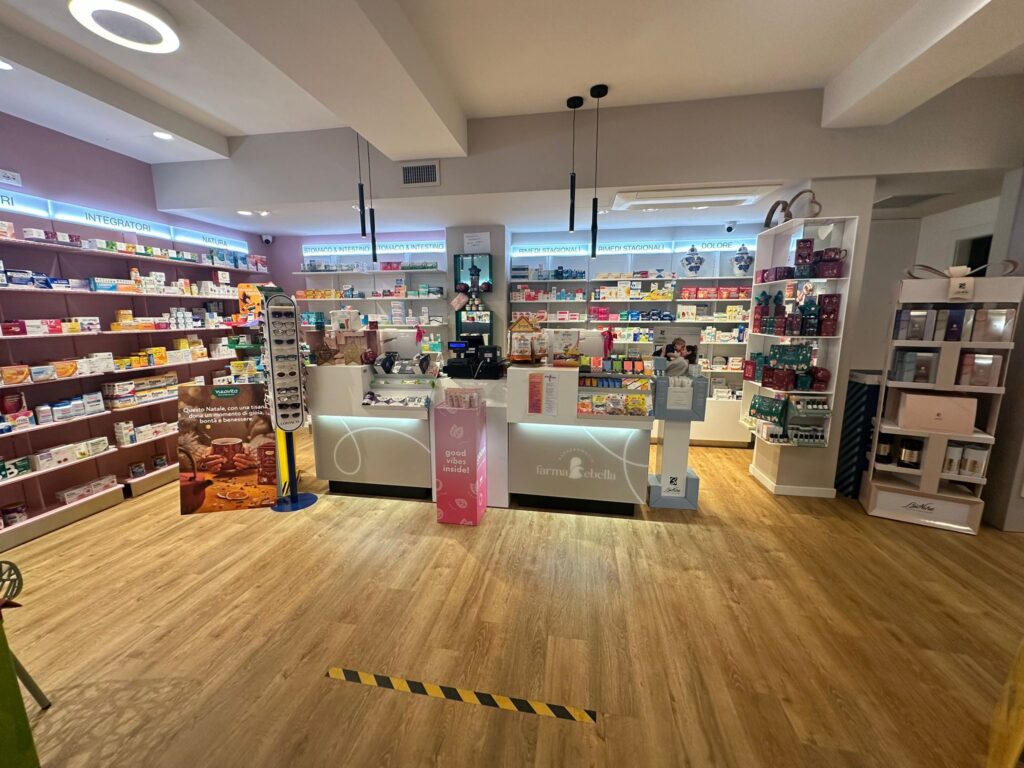 Banco vendita della parafarmacia con scaffalature illuminate e lampade a sospensione