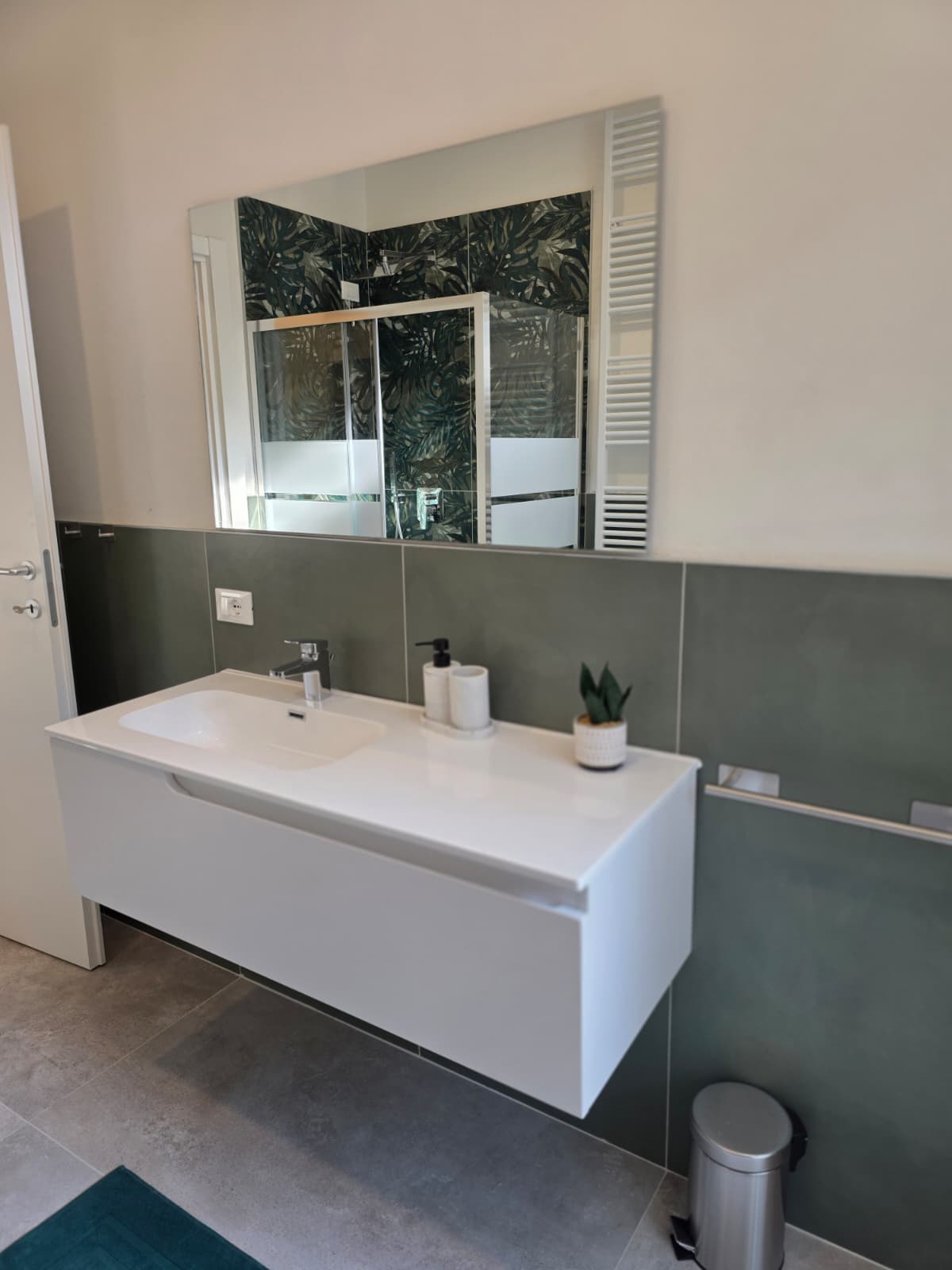 Bagno privato con lavabo sospeso e rivestimento verde nello studentato