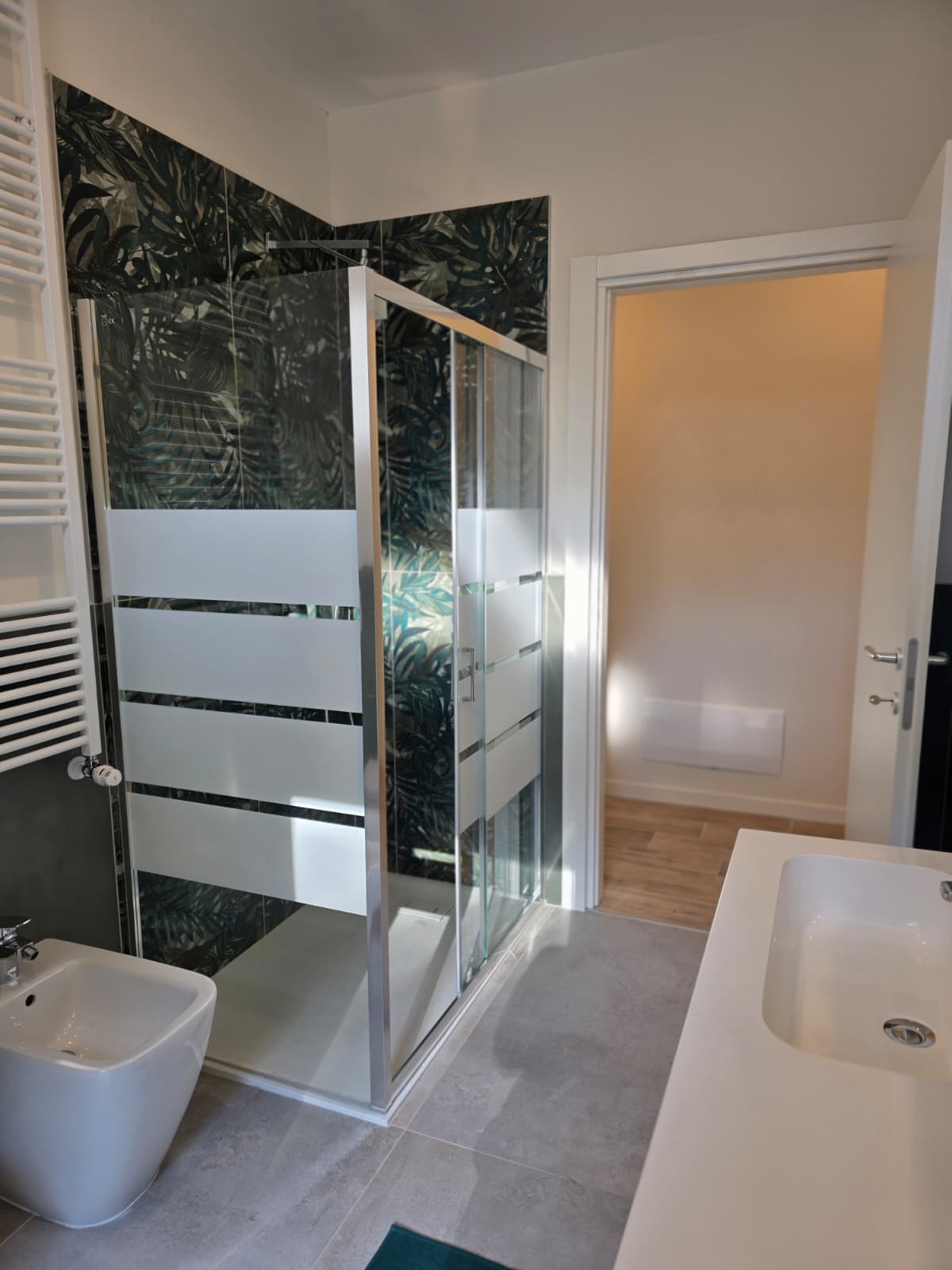 Doccia con rivestimento decorato e box in cristallo nel bagno dello studentato