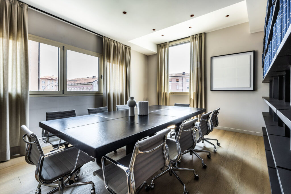 Sala riunioni dello studio notarile ABM a Brescia con tavolo in essenza scura e affaccio sulla citta