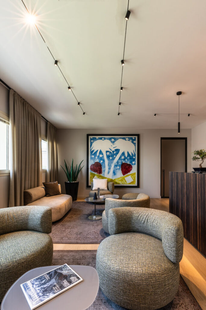 Sala di attesa dello studio notarile con sedute curve e opera d arte di grande formato