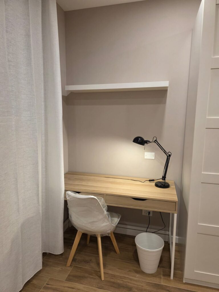 Postazione di studio ricavata in una nicchia con scrivania e lampada