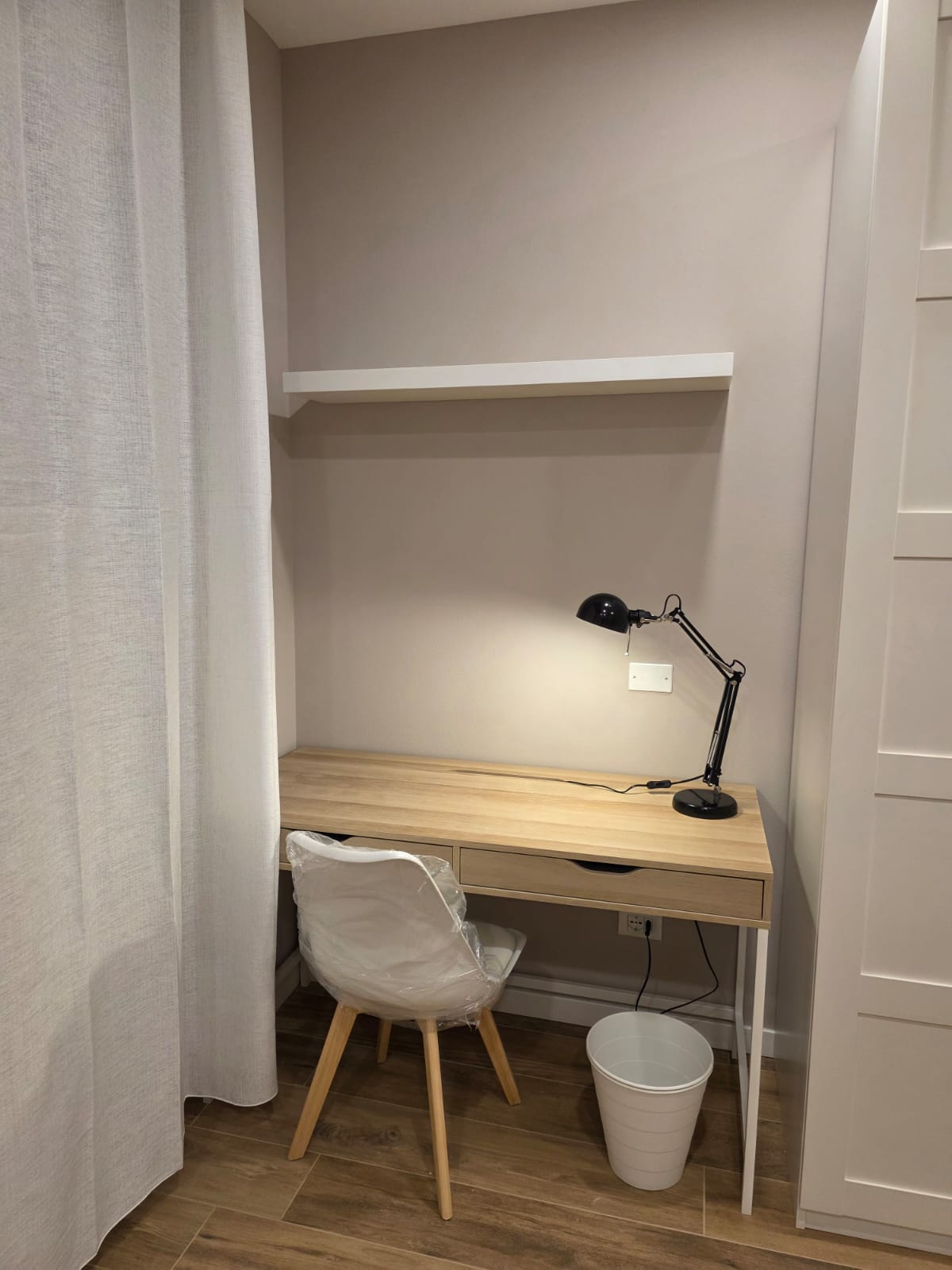Postazione di studio ricavata in una nicchia con scrivania e lampada
