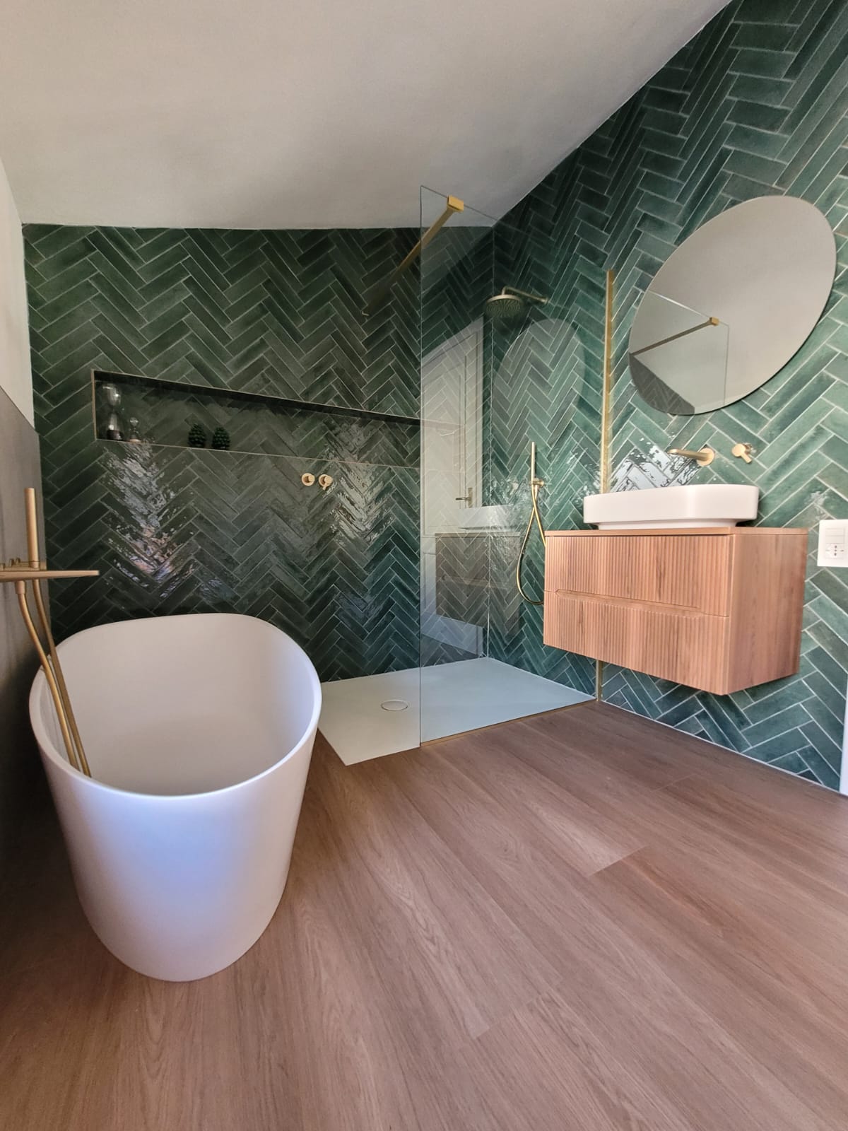 Bagno con vasca freestanding e piastrelle verde smeraldo a spina di pesce, ristrutturazione di un appartamento a Brescia