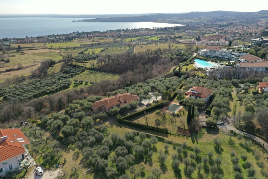 Vista aerea delle colline moreniche di Soiano del Lago con uliveti e il lago di Garda sullo sfondo